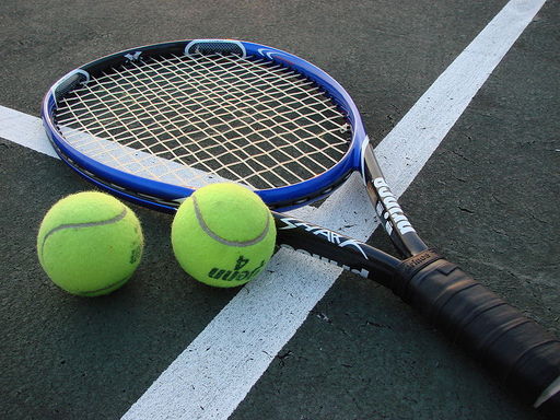 Photograph of a tennis racket and two balls