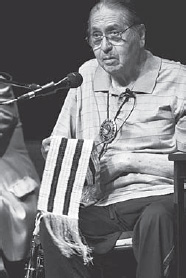 Onondaga Nation Chief Irving Powless Jr. displays the two-row wampum belt at the Onondaga Land Rights forum at Syracuse Stage, July 13, 2010 (photograph by Mike Greenlar, Courtesy Mike Greenlar)