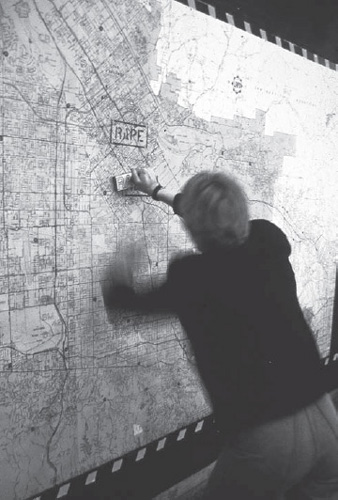 Suzanne Lacy stamping “rape” on map of Los Angeles in Three Weeks in May, May 1977, City Mall in City Hall, Los Angeles (Suzanne Lacy)