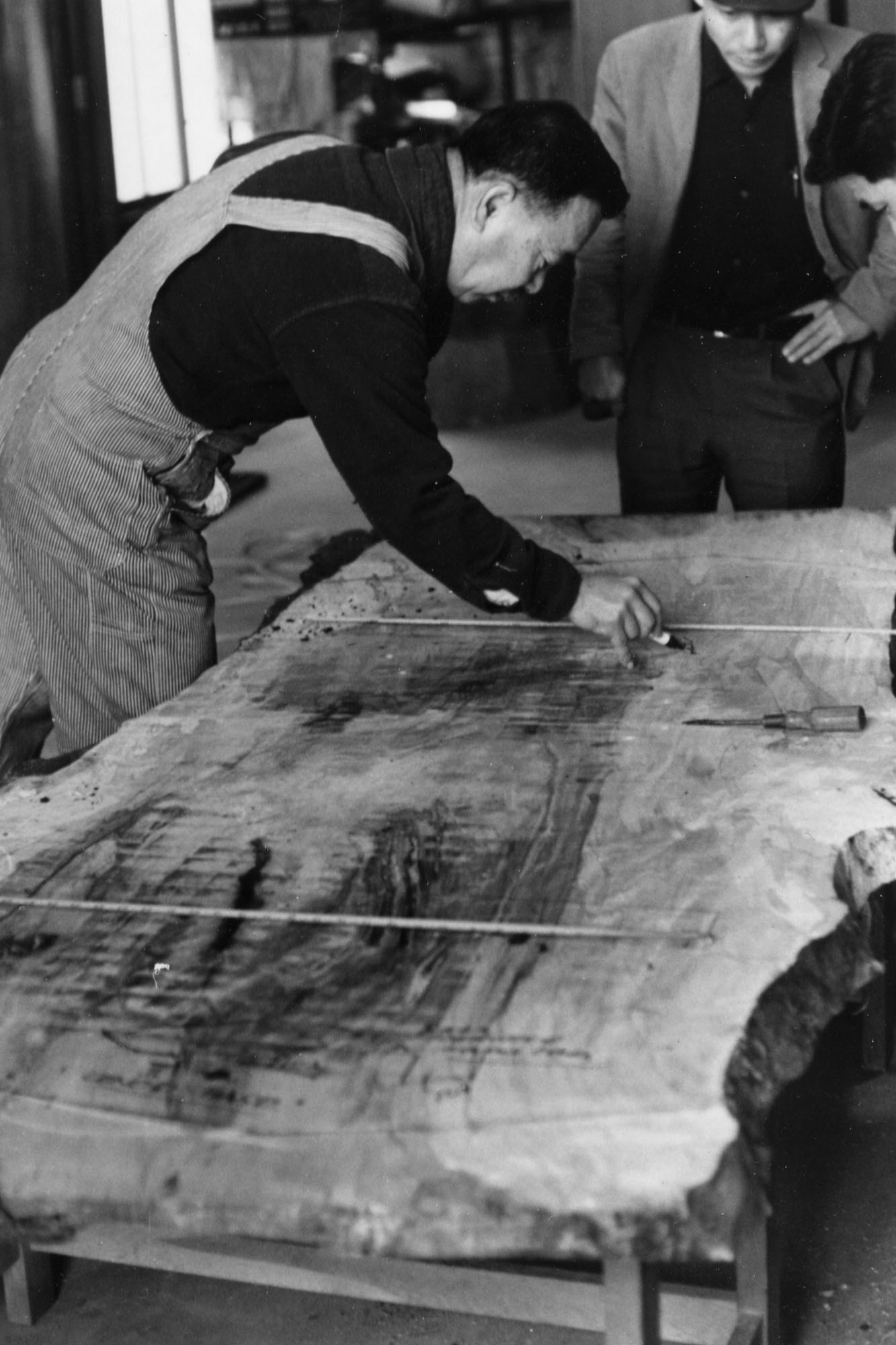 Photo of Nakashima laying out lumber for cutting at Sakura Seisakusho, Takamatsu, Japan, c. 1968.