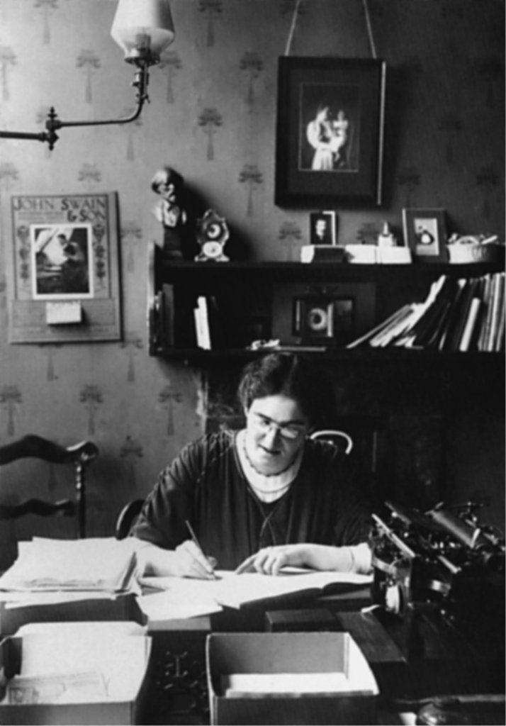 Plate 12. Marion Phillips at work in the Women’s Labour League office (c.1913) under a photograph of Margaret MacDonald.