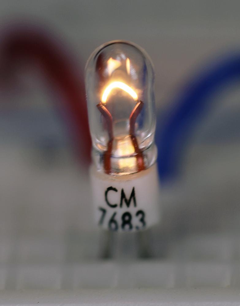 A miniature lamp less than 0.4” high, terminating in pins spaced 0.05” apart.