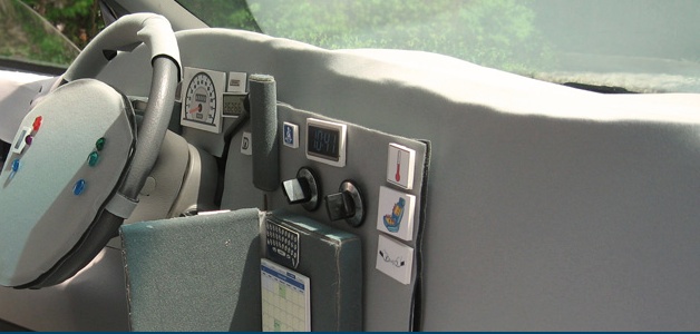 Participants in a co-design exercise stick paper cards representing different types of functionality, such as a calendar and a keyboard, to a real car’s steering wheel and dashboard; note that the existing features are covered up to provide a blank canvas (image: SonicRim)