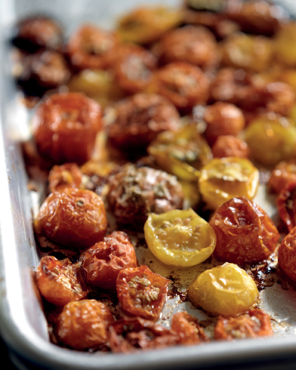 A sheet pan filled with roasted halves of cherry and grape tomatoes