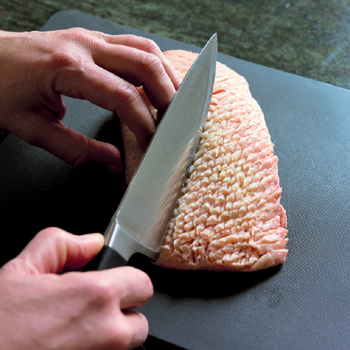 Slicing an uncooked duck breast