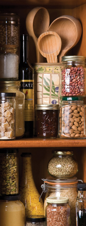 Shelves in a pantry filled with glass jars of all different sorts of ingredients