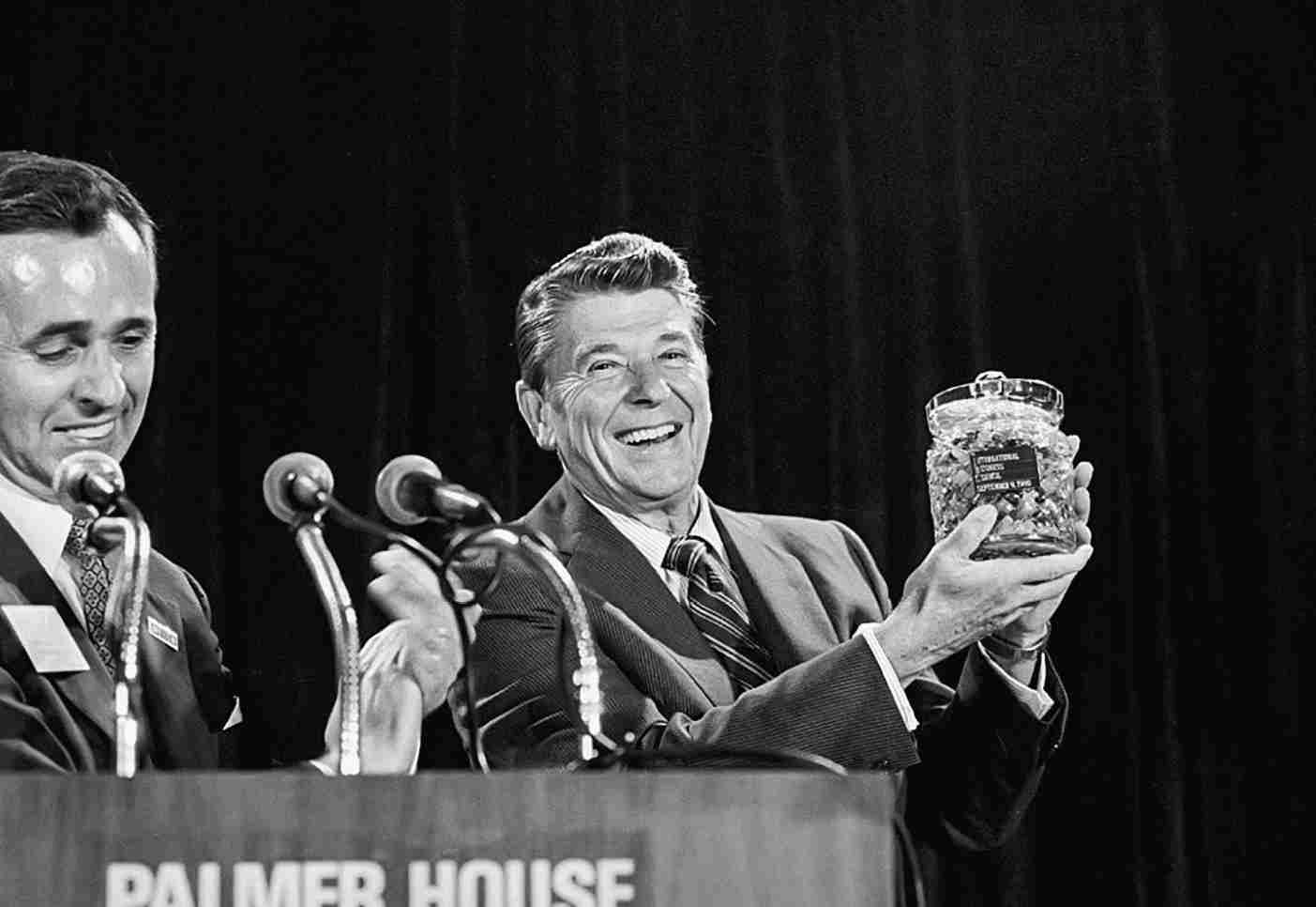 (Original Caption) 9/9/80-Chicago, Illinois: Republican presidential candidate Ronald Reagan holds a crystal jar of jellybeans presented to him 9/9 by Clyde Dicky, Jr., president of the International Business Council. In his address, Reagan offered a five-point program he promised would be instituted his first 90 days in office. Ph: Ron Edmonds