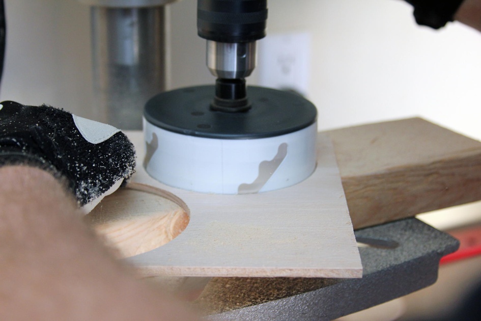 You can cut the circular pieces with a scroll saw, but it’s a lot easier with a hole saw like this one, seen cutting the 4” center disk.