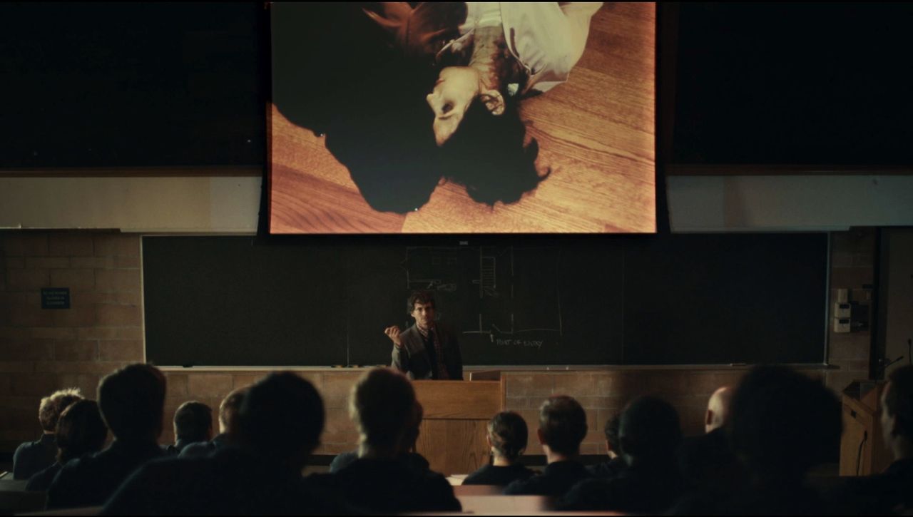 Frame from the Hannibal pilot with Will Graham in an FBI classroom projecting an image of a murder victim.