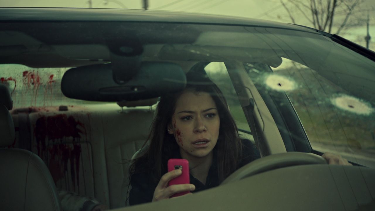 Frame from Orphan Black pilot with Sarah Manning in the bullet-riddled car answering a cell phone call.