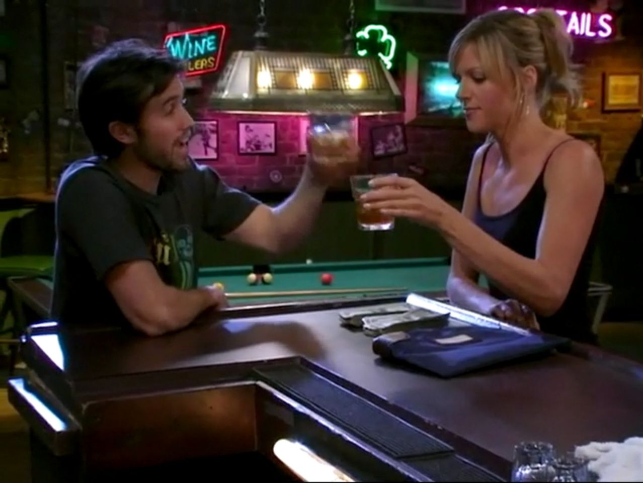 In frame from It’s Always Sunny pilot, Mac and Sweet Dee toast to the bar’s return to dismal business.