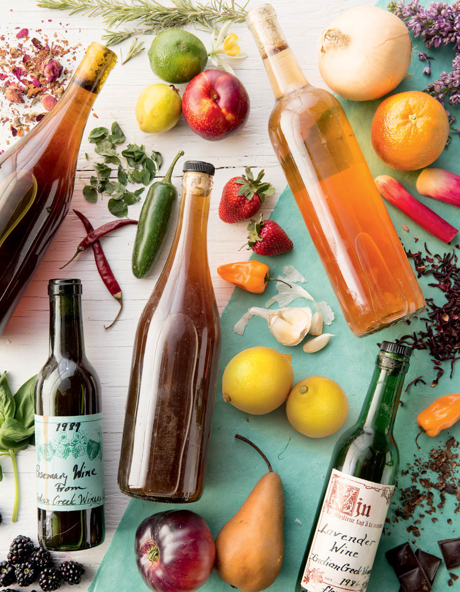 Decorative photo  of various bottled wines and their ingredients (fruits, herbs, vegetables)