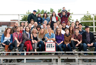 A group of young people sitting in bleachers - apparently the staff of Joe Beef.