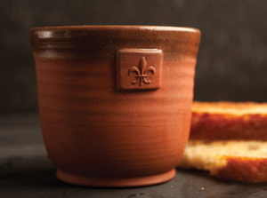 A pottery crock set with a fleur de lis logo