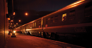 A train platform at night with a train on the tracks