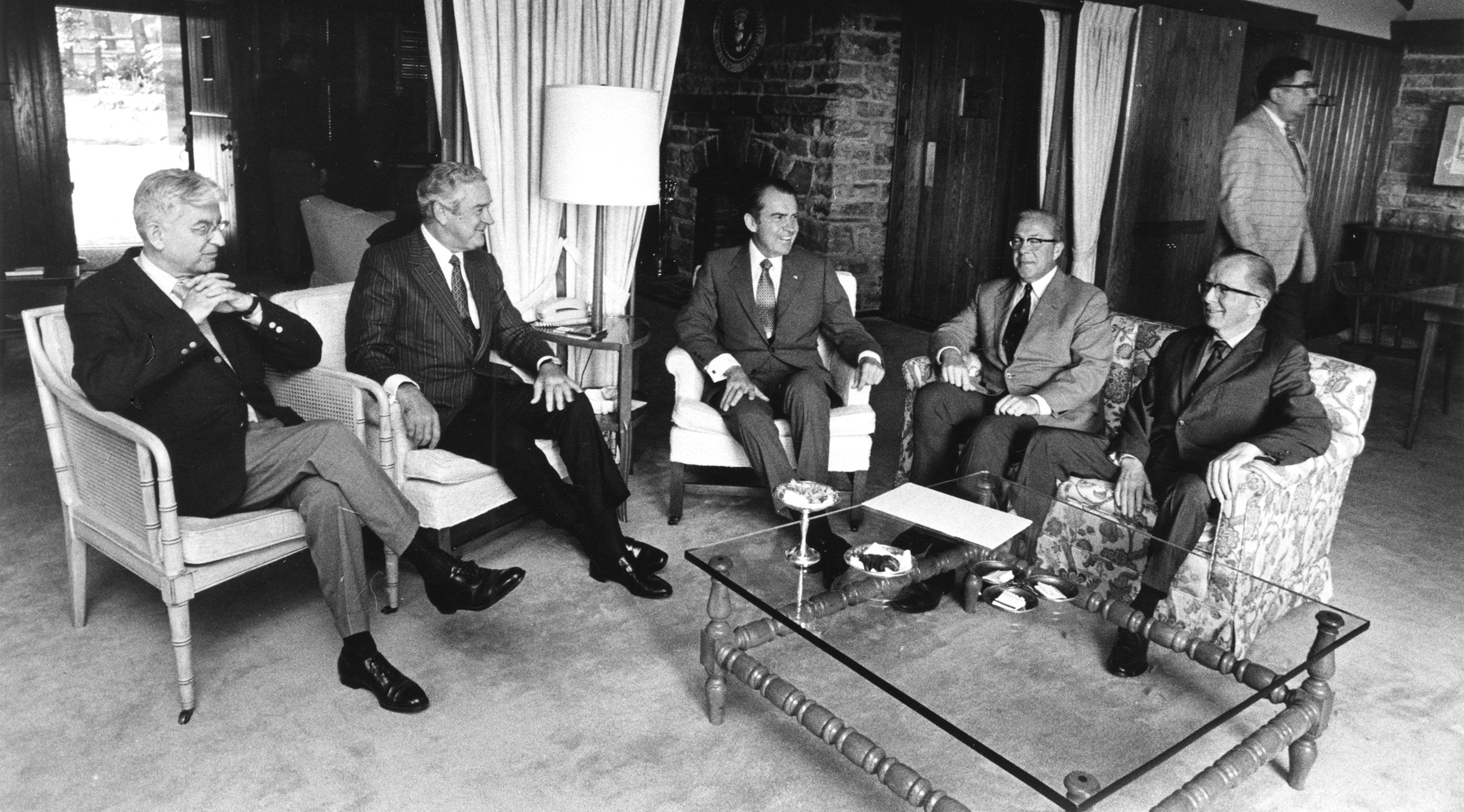 (<i>From left</i>) Federal Reserve chairman Arthur Burns, Treasury secretary John Connally, President Richard Nixon, Office of Management and Budget director George Shultz, and Council of Economic Advisers chair Paul McCracken at Camp David in August 1971, the weekend before unveiling the president’s New Economic Program wage and price controls. Participants were instructed not to tell their families where they were headed in order to maintain the secrecy (and the theatrical nature) of the discussions. Having lost the argument against controls, McCracken would resign following the president’s announcement. <i>Ollie Atkins for the White House. George Pratt Shultz papers, Box 732, Hoover Institution Archives.</i>