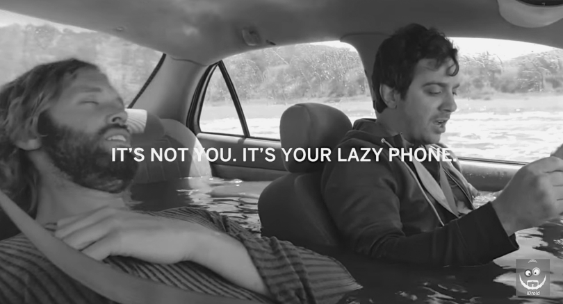 Figure depicting ad campaign for Motorola phone where two men are sitting in a car half submerged in water. The man on the left is sleeping while the man on the right is reading something. The ad headline reads, “It's not you. It's your lazy phone.”