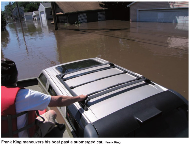 Frank King maneuvers his boat past a submerged car. Frank King