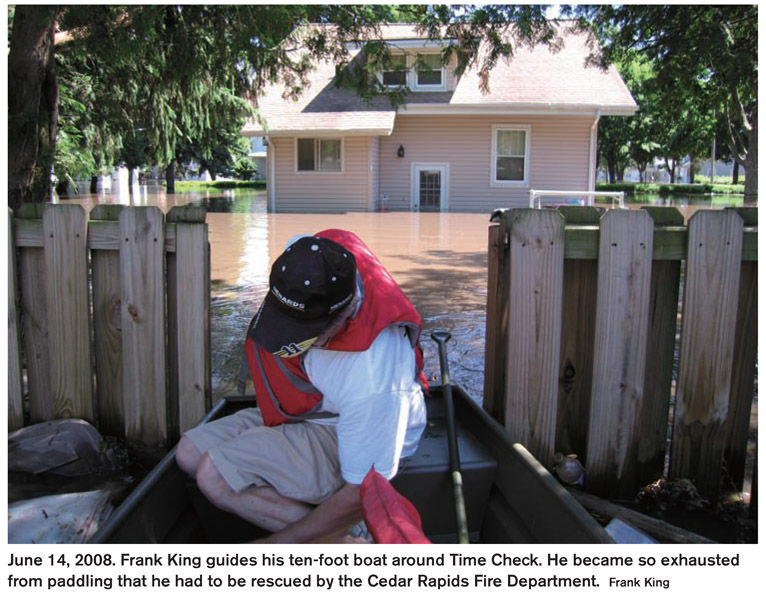 June 14, 2008. Frank King guides his ten-foot boat around Time Check. He became so exhausted from paddling that he had to be rescued by the Cedar Rapids Fire Department. Frank King