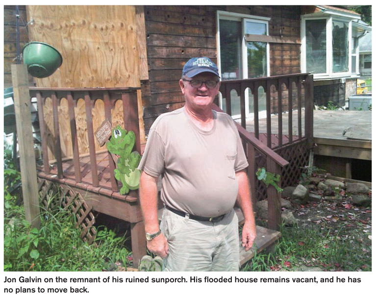 Jon Galvin on the remnant of his ruined sunporch. His flooded house remains vacant, and he has no plans to move back.