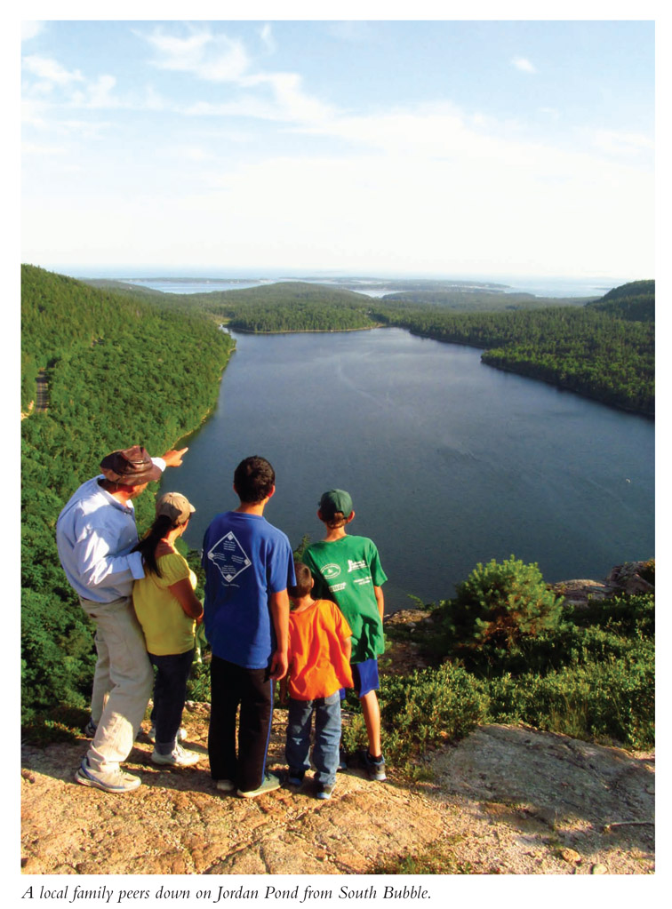 A local family peers down on Jordan Pond from South Bubble.