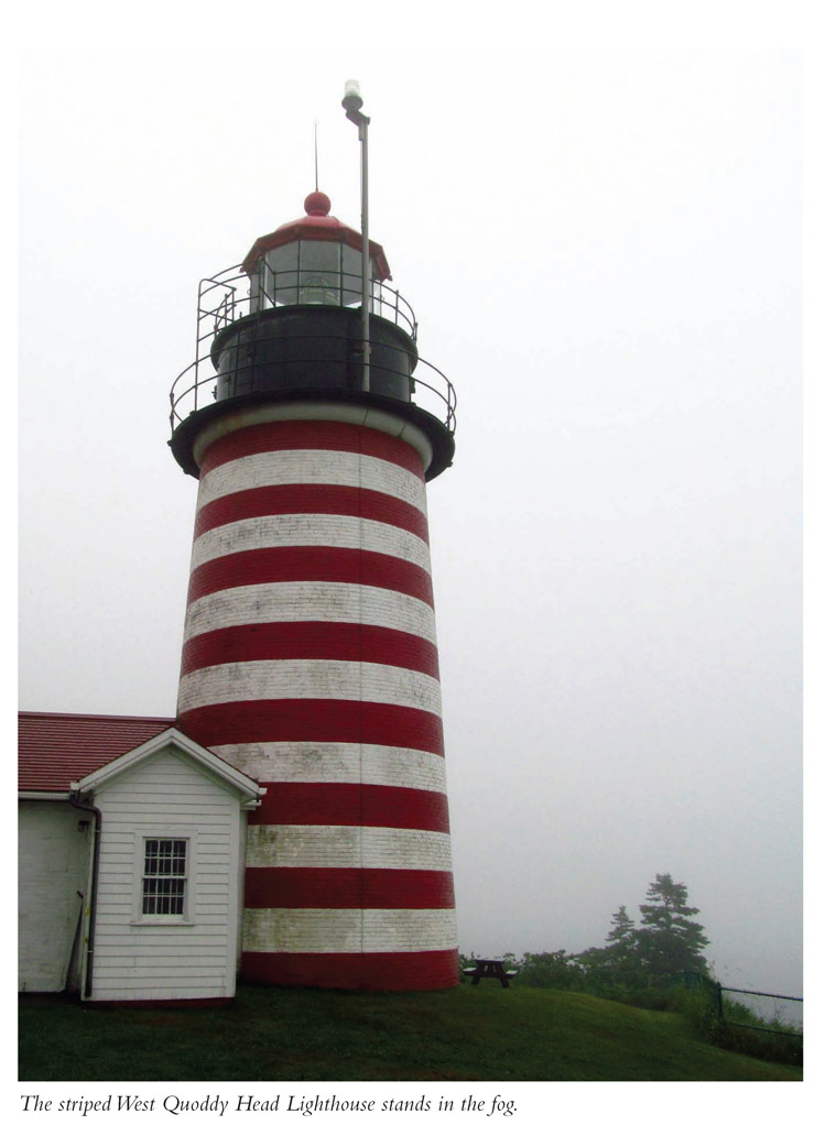 The striped West Quoddy Head Lighthouse stands in the fog.