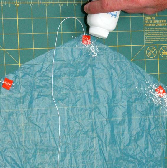 Apply talcum powder to keep the top side of the tape from sticking when the parachute is folded.