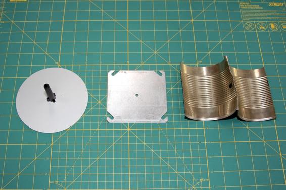 Three of the many choices for blast deflector plates. From left to right: the Estes blast deflector, a blast deflector made from a metal plate, and a blast deflector made from a tin can.