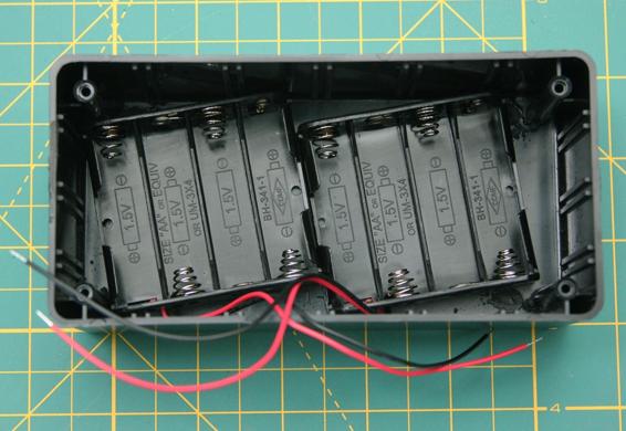 Battery holders glued to the bottom of the project box. Twist them to make room where the cigarette lighter socket will protrude into the box.