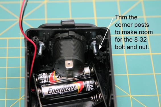 Install the cigarette lighter socket. You will need to trim the corner posts to make room for the nuts. Install the first two batteries before inserting the socket; they can’t be inserted with the socket in place.