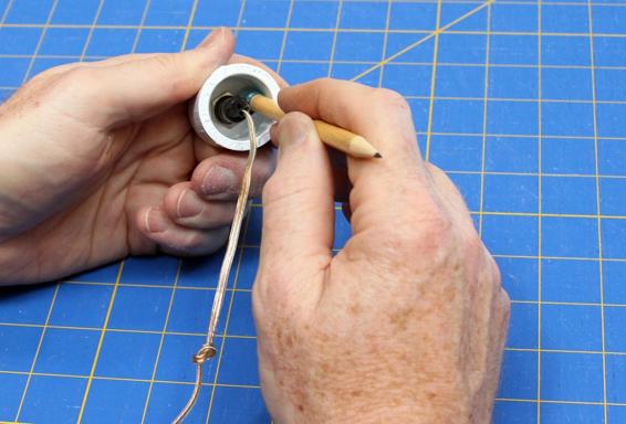 Install the launch button in one end cap. The knot in the wire will pull up against the hole in the bottom end cap, so tugging the wire doesn’t put strain on the soldered connections.