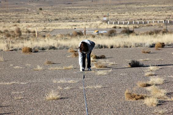 The baseline is often longer than your tape measure. Here, the author and his lovely assistant are setting up a 300-foot baseline with a 100-foot tape measure. The end of the first 100 feet is located, and then the tape measure is held there and extended another 100 feet. The tape measure is in a line with the launcher, seen behind the post in the background.