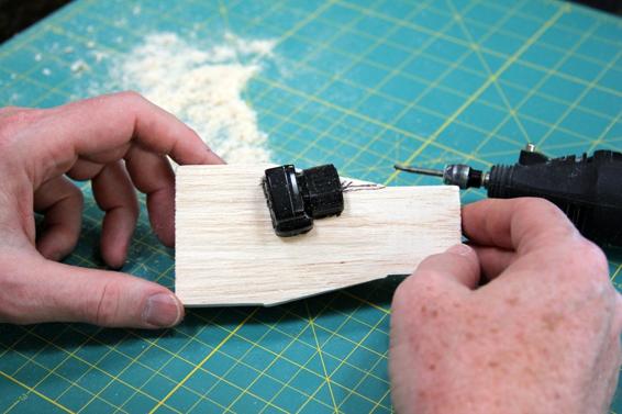 After outlining the camera, slowly carve out a cavity until the camera lens sits centered on the split in the wood.