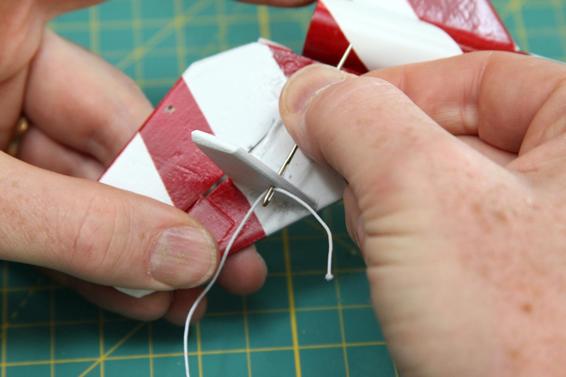 Use a large needle or toothpick to install the elastic thread that pulls the flap into place.