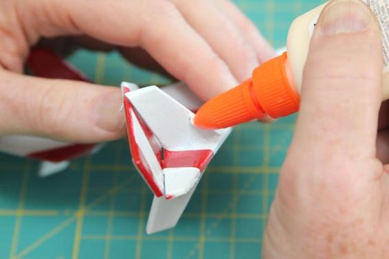 After knotting the elastic thread, add a dab of glue to reinforce the knot and the hole where the thread goes through the balsa.