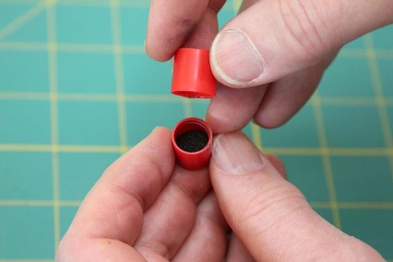 Remove the larger plastic cap, leaving the ejection charge in the smaller cap.