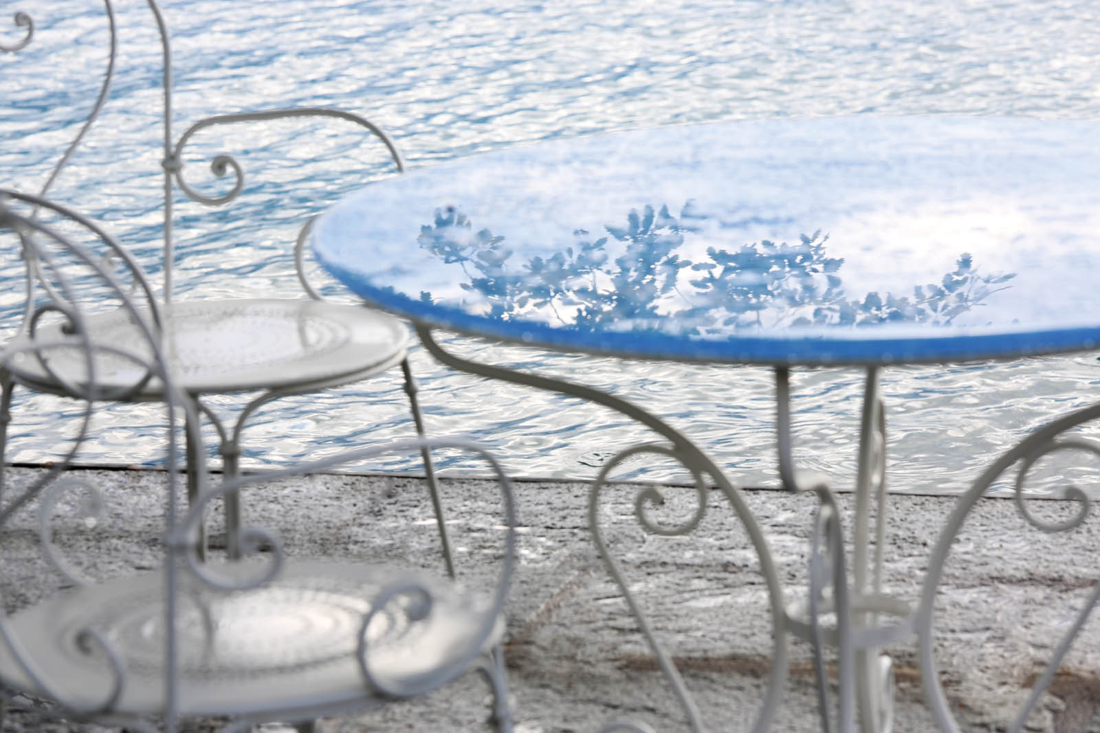 Photo of a glass table by the water.