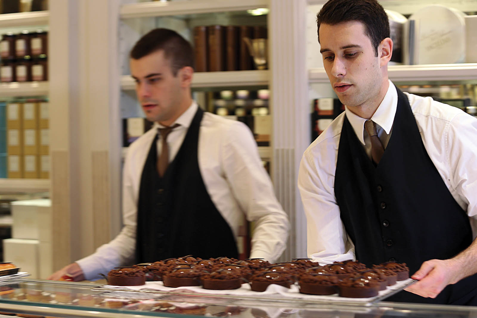 Photo of servers with trays of desserts.