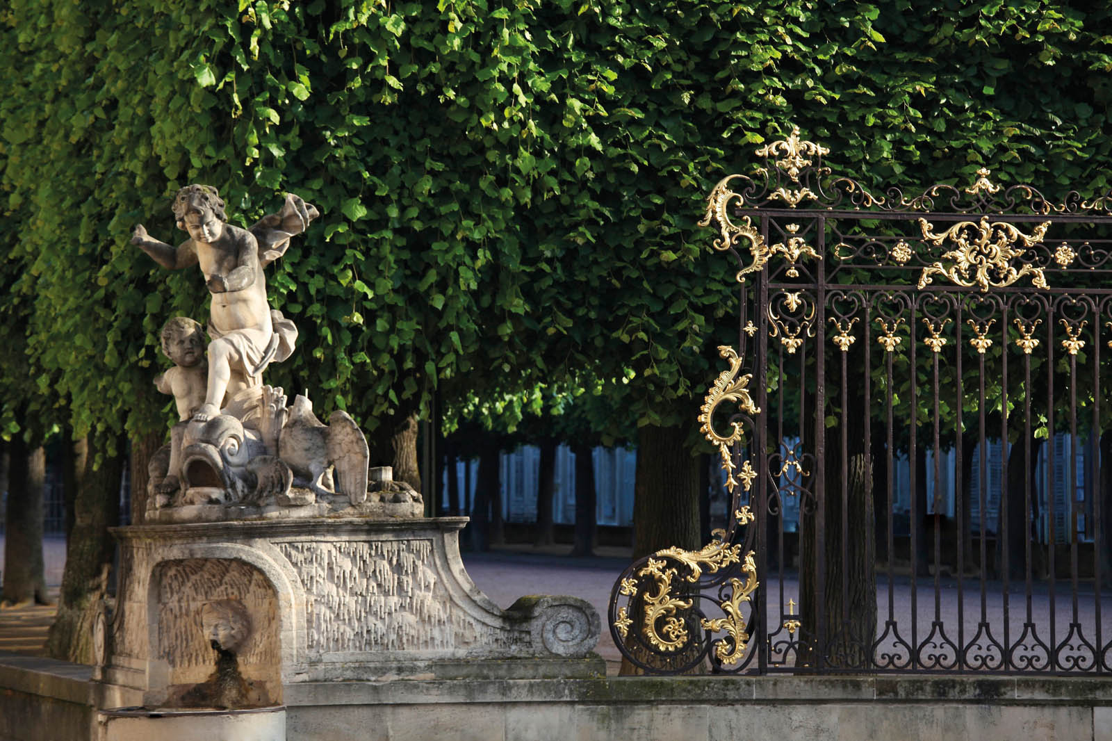 Photo of a statue near a gilded fence.