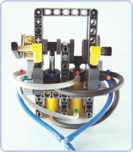 A two-cylinder engine built in accordance with the rules above. The colored dots show which ports are connected. Note the position of the cams. The engine can start all by itself and runs relatively smoothly. The tan gear can transfer drive from the engine. More cylinders can be added to the engine, and it reaches optimum smoothness with four cylinders, each with a cam rotated 90 degrees relative to the next one.