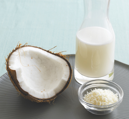 A coconut, coconut shavings, and coconut milk