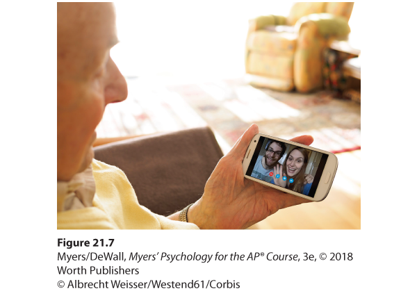 A photo shows a man face timing a woman and a man, who are seen smiling at him on his phone screen.