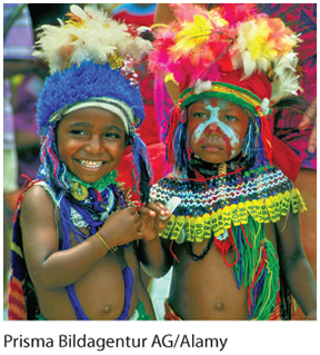 This image is a photograph of two children in papua new guinea, wearing traditional clothing.