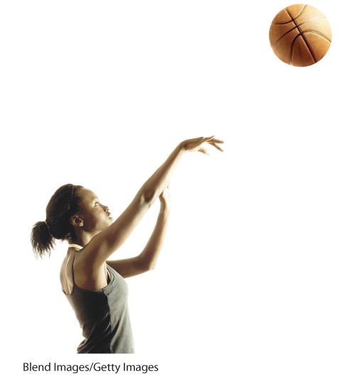 A photo shows a woman shooting a basketball in the air.