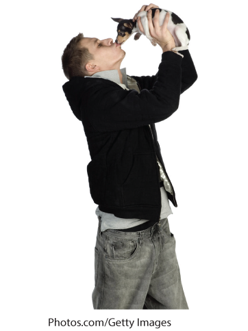 A photo shows a man kissing a puppy.