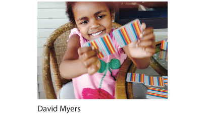 A photo of a girl holding up two memory game cards.