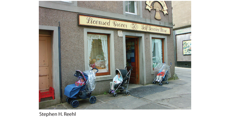 A photo shows toddlers in their strollers outside a shop left unattended.