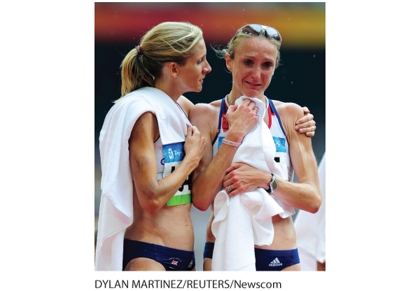 A photo shows two female athletes, one crying and the other comforting her.