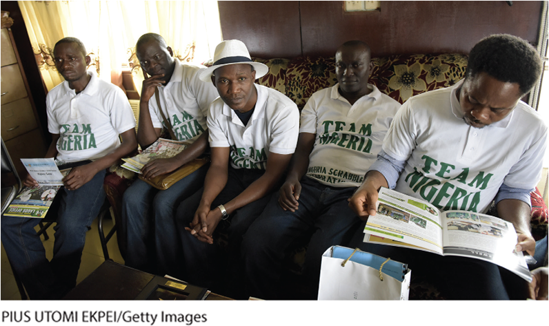 A photo shows five people sitting on a couch including Wellington Jighere in the center, wearing Team Nigeria jersey.