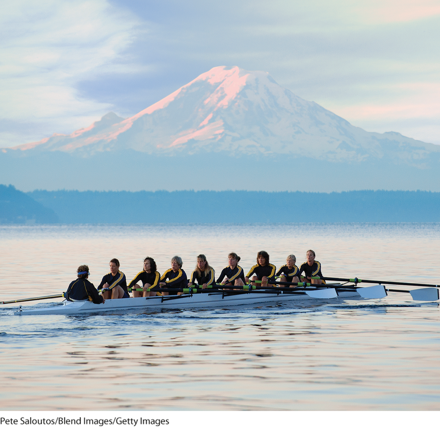 A photo shows a team of people rowing a boat.